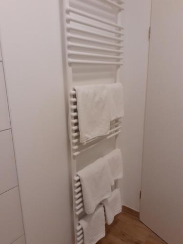 baño con toallas blancas colgadas en un armario en Ferienwohnung Diana, en Wilhelmshaven