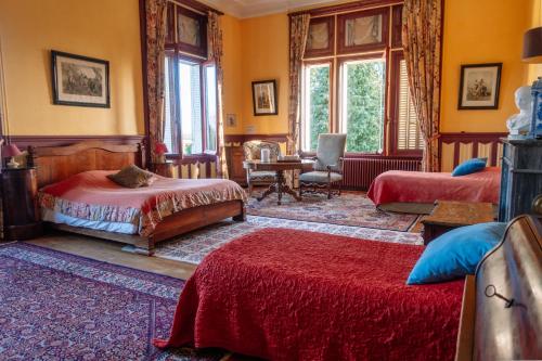 1 dormitorio con 2 camas y mesa con silla en Château Le Boisrenault en Buzançais