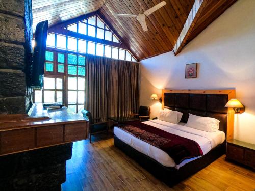 a bedroom with a bed and a large window at Apple Valley Resort in Kulu