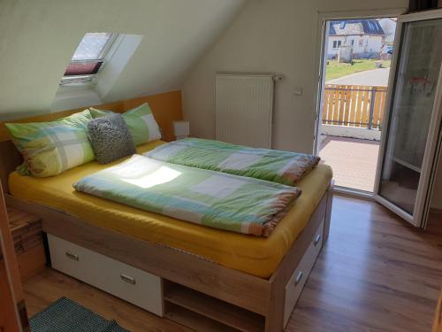 a bedroom with a large bed with a balcony at Ferienhaus an See in Nohfelden