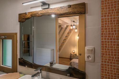 a bathroom mirror with a sink and a bed at Chambres D'H&Ocirc;TES in Vezin-le-Coquet