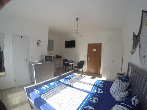 a bedroom with a bed and a kitchen and a desk at Haus Fernsicht in Thiessow