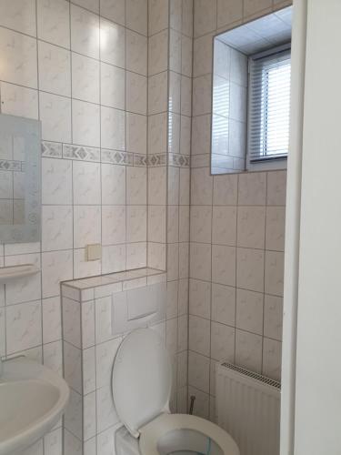 a white bathroom with a toilet and a sink at Haus Fernsicht in Thiessow