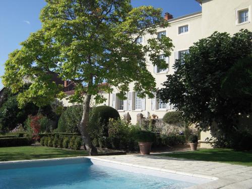 une piscine en face d'un grand bâtiment blanc dans l'établissement Demeure Bouquet, à Ambierle