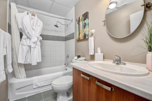 a bathroom with a sink and a toilet and a mirror at The Willowdale Hotel Toronto North York in Toronto