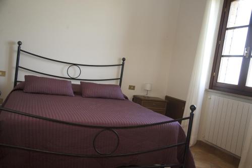 a bed with two purple pillows in a bedroom at Il Fornello in Volterra