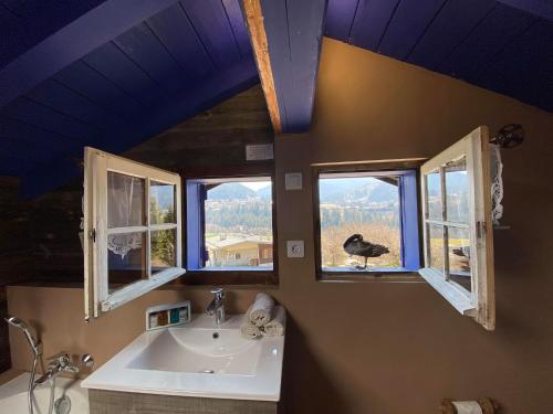 a bathroom with a sink and a window with a bird in it at Le Petit Nid d'Amour, Propriétés Mont Amour in Montriond