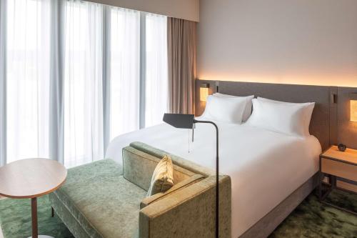 a hotel room with a large bed and a couch at Hyatt Regency Zurich Airport Circle in Kloten