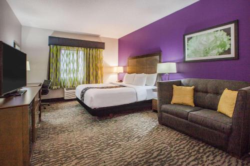 a hotel room with a bed and a couch at La Quinta Inn and Suites by Wyndham Elkhart in Elkhart