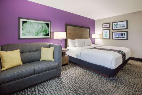 a hotel room with a bed and a couch at La Quinta Inn and Suites by Wyndham Elkhart in Elkhart