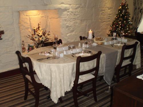 a dining table with a christmas tree in a room at Shawlee Cottage in Airdrie