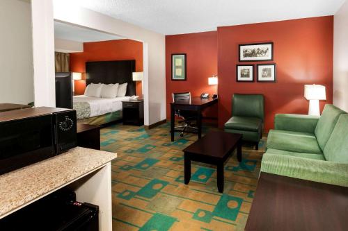 GlendaleにあるLa Quinta by Wyndham Milwaukee Bayshore Areaのベッドとリビングルームが備わるホテルルームです。