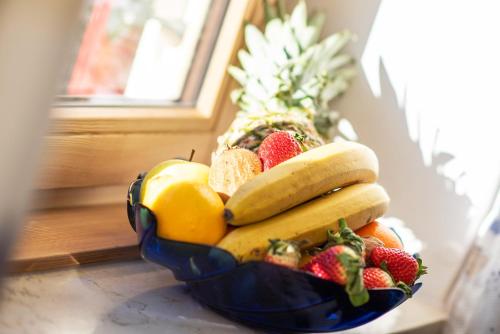 a bowl of fruit on a table with a pineapple at Garni Gartenheim in Caldaro