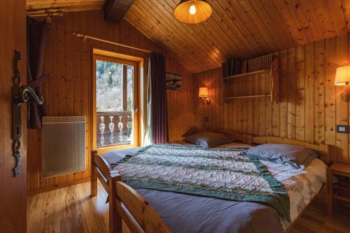 1 dormitorio con 1 cama en una cabaña de madera en L'arpont, en Champagny-en-Vanoise