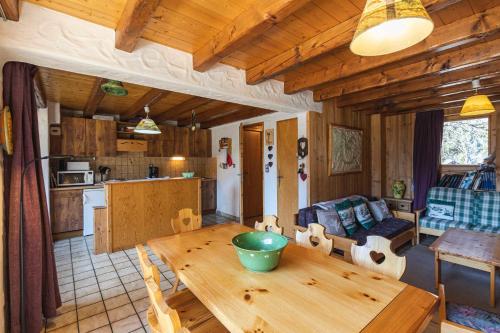 cocina y sala de estar con mesa de madera en L'arpont, en Champagny-en-Vanoise