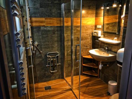 y baño con ducha y lavamanos. en Hôtel & Spa La Ferme de l'Izoard en Arvieux