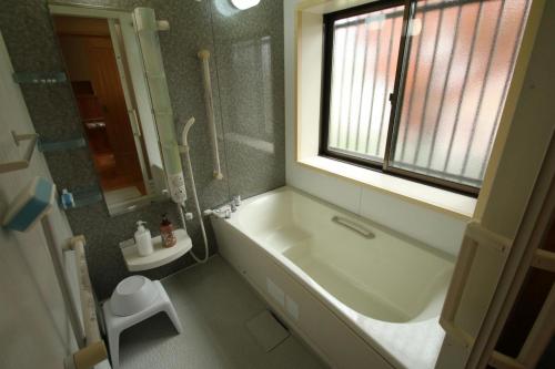 baño con bañera y ducha y ventana en Aso - House / Vacation STAY 79474, en Aso