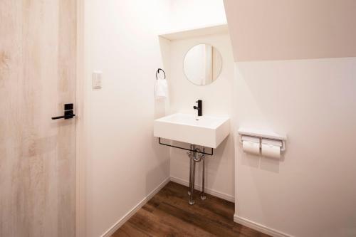 a white bathroom with a sink and a mirror at HOTEL LITTLE BIRD OKU-ASAKUSA / Vacation STAY 79431 in Tokyo
