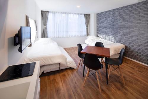 1 dormitorio con 1 cama, mesa y sillas en HOTEL LITTLE BIRD OKU-ASAKUSA / Vacation STAY 79448 en Tokio