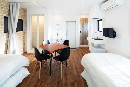 um quarto com duas camas e uma mesa e cadeiras em HOTEL LITTLE BIRD OKU-ASAKUSA / Vacation STAY 79442 em Tóquio