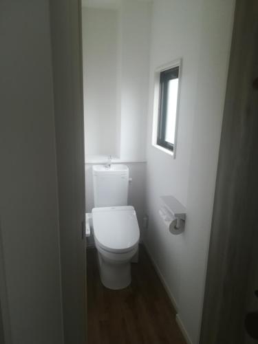 een wit toilet in een badkamer met een raam bij HOTEL LITTLE BIRD OKU-ASAKUSA / Vacation STAY 79446 in Tokyo
