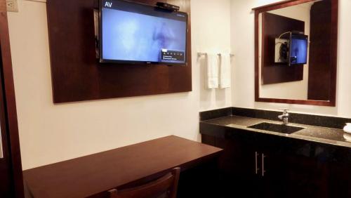 Una televisión o centro de entretenimiento en Hotel Rincon Real Suites