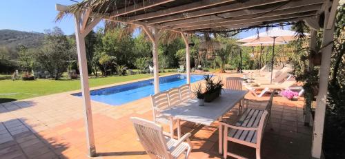 カルデス・デ・マラベーリャにあるVILLAS COSETTE - Villa Melbaのプールサイドのパティオ(テーブル、椅子付)