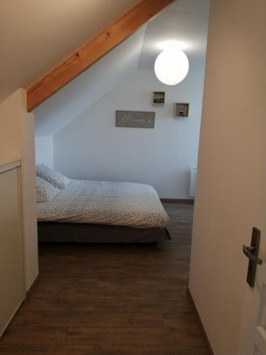 - une chambre avec un lit et une croix sur le mur dans l'établissement Chez Magali et Aymeric, à La Méaugon