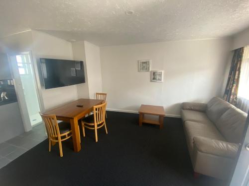 a living room with a couch and a table at Grove Park Motor Lodge in Blenheim