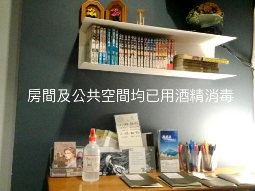 ein Bücherregal mit Büchern auf einem Schreibtisch in der Unterkunft Flying Backpacker in Yilan