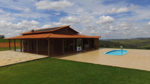 a small building with a pool in front of it at Sítio Luar in São Roque de Minas