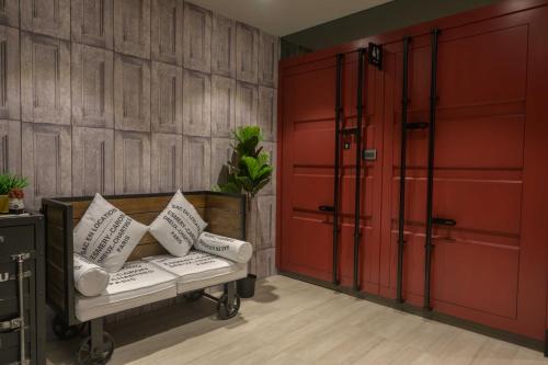a room with red doors and a bench with pillows at K HOTEL in Taichung