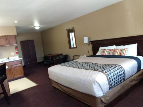 a hotel room with a large bed and a desk at royal inn in Lovelock
