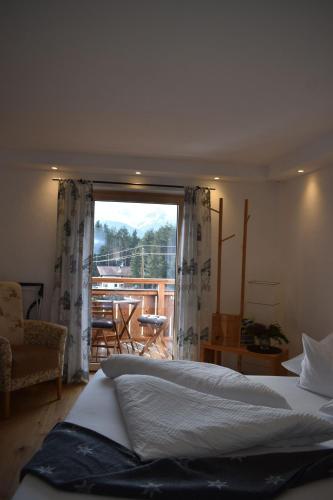 a bedroom with a bed and a view of a balcony at Bucherhof in Obsteig