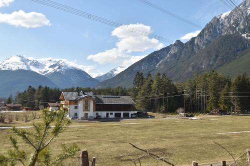 a house in a field with mountains in the background at Bucherhof in Obsteig
