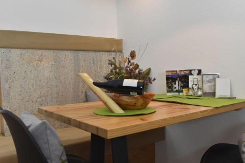 a wooden table with a bowl of flowers on it at Bucherhof in Obsteig