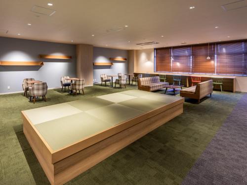 a waiting room at a hospital with chairs and tables at Tosei Hotel & Seminar Makuhari in Narashino