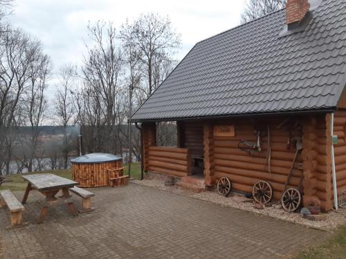 a log cabin with a picnic table next to it at Beibuki in Naujene