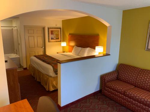 a hotel room with a bed and a couch at Baymont by Wyndham Cave City in Cave City