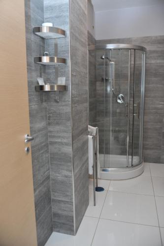 La salle de bains est pourvue d'une douche avec une porte en verre. dans l'établissement Hotel Il Cavaliere, à Sarno