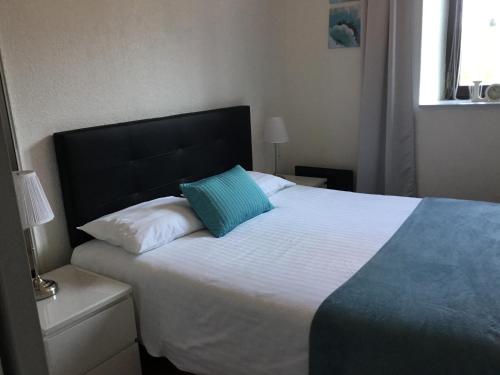 - une chambre avec un grand lit et un oreiller bleu dans l'établissement A coté de Genève 2, à Saint-Cergues