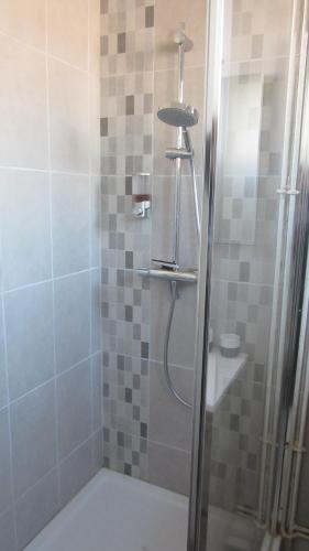 La salle de bains est pourvue d'une douche avec une porte en verre. dans l'établissement Sweethome-Epinal, à Épinal