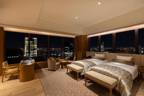 a bedroom with two beds and a view of a city at The Okura Tokyo in Tokyo