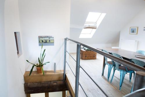 a room with a staircase and a table and chairs at Maison Sainte-Marguerite in Liège