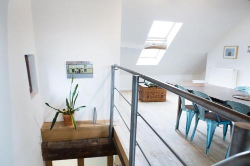 une chambre avec un escalier, une table et des chaises dans l'établissement Maison Sainte-Marguerite, à Liège