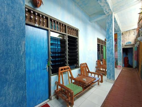 a room with two chairs and a window at Lovina Central Hostel in Lovina