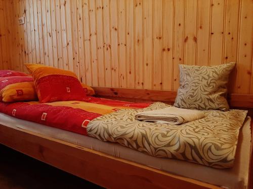 a bed in a room with some pillows on it at Kiskastély Fogadó-Étterem in Füzesgyarmat