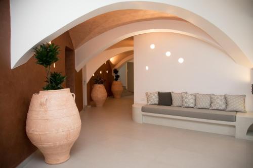 a hallway with a large vase and a couch at Pelican Hotel in Fira