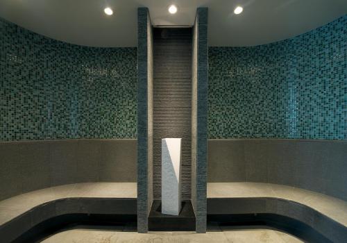 a bath tub in a room with green tiles at The Okura Tokyo in Tokyo