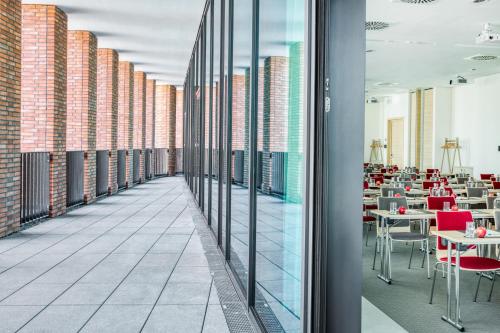 a corridor of a restaurant with tables and chairs at IntercityHotel Hamburg-Barmbek in Hamburg